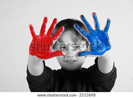 a young artist with very colorful hands.  Black and white face with red and blue hands.