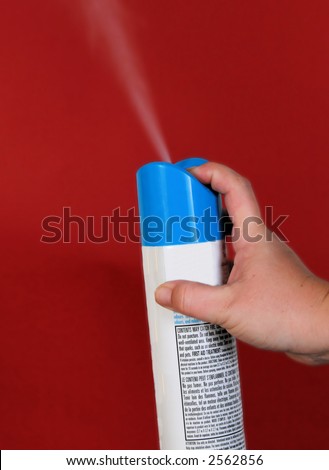 air freshener being sprayed in the air.  Isolated by a bright red background