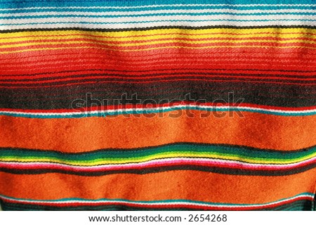 A hand woven mexican blanket that is very colorful.