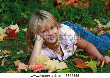 Cute little girl with all the fall autumn leaves.
