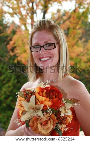 Beautiful bridesmaid all dressed in fall colors with fall leaves in background.