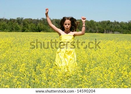 Happy girl jumping in the fields of flowers.