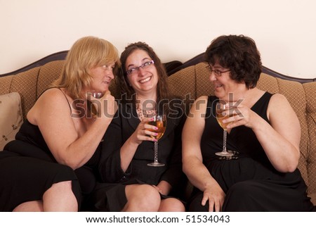 Three well dressed and diverse woman socializing with wine.