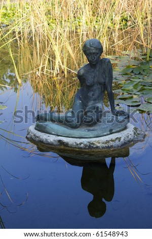 Vintage statue reflecting in the water, at a public park