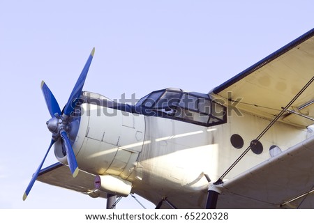 Closeup of vintage biplane with blue propeller.