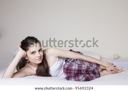 Young woman in the bed, in lila pijama and white top
