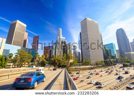 Downtown Los Angeles skyline during rush hour with blue sky