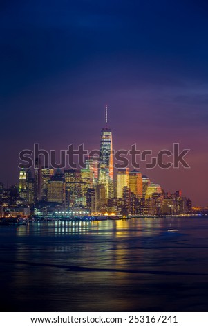 New York City with skyscrapers illuminated over Hudson River panorama, including the One World Trade Center