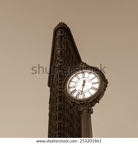 NEW YORK CITY - FEB 11: Sidewalk clock and Flat Iron building, considered to be one of the first skyscrapers ever built, with New York City street view. February 11, 2015 in Manhattan, New York City.
