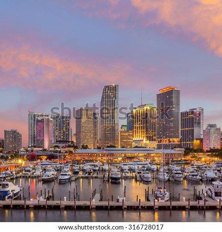 Miami city skyline panorama at twilight with urban skyscrapers, marina and bridge USA