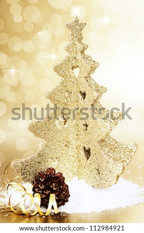 Gold christmas tree and cone on gold background