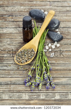 lavender aromatherapy (fresh and dried lavender flowers,  essential oil, zen stones, salt) on a wooden surface