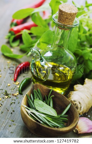 fresh  herbs, olive oil and vegetables on cutting board