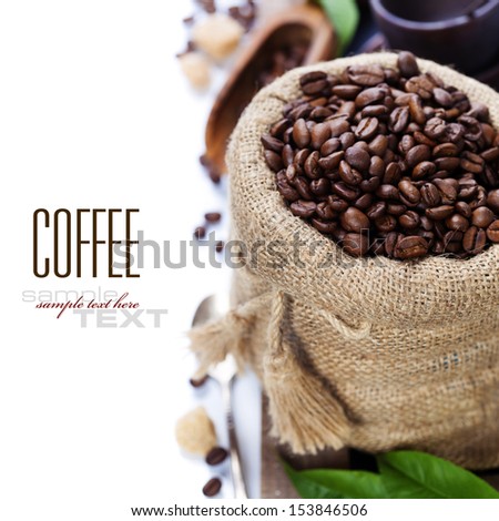 Coffee beans in burlap sack with wooden scoop  over white (with sample text)
