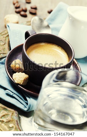 Tray with fresh coffee, milk, water and sugar over white