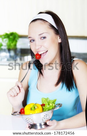 Young woman with salad in the  kitchen