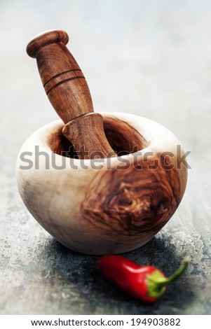 Red Hot Chili Peppers with Mortar and Pestle over wooden background