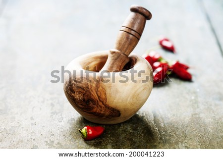 Red Hot Chili Peppers with Mortar and Pestle over wooden background
