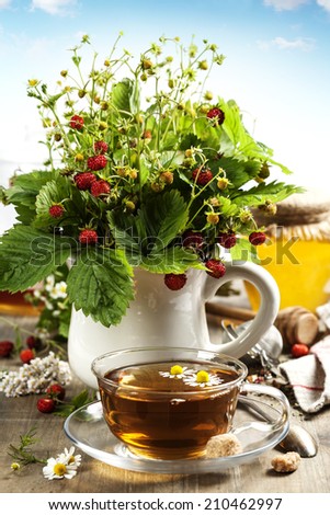 bouquet of wild strawberry with herbal tea and honey - bio food or health concept