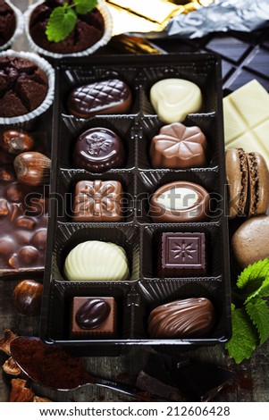 An assortment of fine chocolates in white, dark, and milk chocolate on wooden board