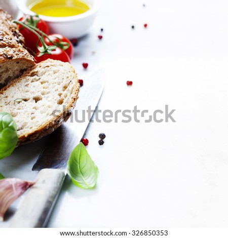 Tomato, bread, basil and olive oil on white marble background. Italian cooking, healthy food or vegetarian concept