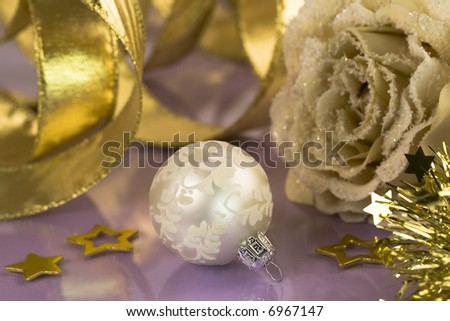Christmas background-Frosted artificial rose, ribbon and white ball on violet background