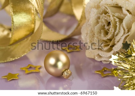 Christmas background-Frosted artificial rose, ribbon and christmas ball on violet background