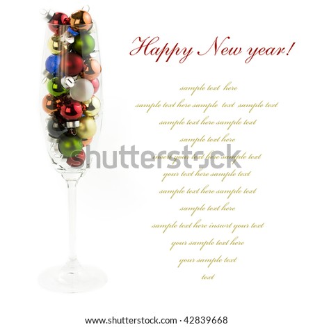 Champagne glass filled with colorful holiday ornaments over white