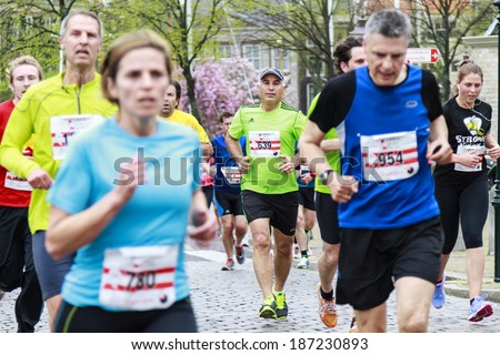 Dordrecht, The Netherlands-April 6, 2014: Athletes running on the old roads of Dordrecht in the 67th edition of Dwars door Dordt, a competition run of 5 and 10 km held in the old city center.