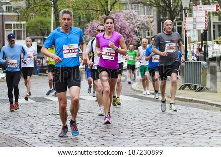 Dordrecht, The Netherlands-April 6, 2014: Participants running on the old roads of Dordrecht in the 67th edition of Dwars door Dordt, a competition run of 5 and 10 km held in the old city center.