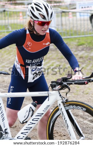 DORDRECHT, NETHERLANDS - APRIL 13 2013: Run Bike Run Bike Run duathlon event organized by TVD. Lindy van Anrooij changes over to cycling stage on the course of the dualthlon just outside Dordrecht.