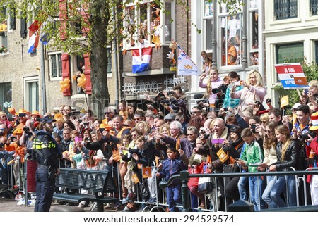 DORDRECHT, THE NETHERLANDS - APRIL 27, 2015: Awaiting crowd taking pictures of the royal family as they pass by during the visit of the Dutch royal family on the traditional Kings Day celebrations.