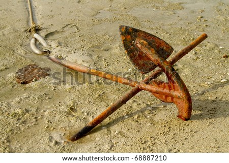 Rusty boats anchor solid in the sand on the coast