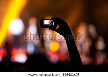 NOVI SAD, SERBIA - JULY 10: Hand with a smartphone records Viva Vox\'s performance at EXIT 2013 Music Festival, on July 10, 2013 at the Petrovaradin Fortress in Novi Sad, Serbia.