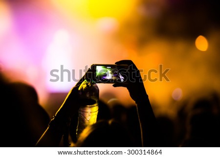 JAZ, MONTENEGRO - JULY 17 2015: Hand with a smartphone infront of the Main stage at SEA DANCE Music Festival - EXIT ADVENTURE, on July 17, 2015 at the Jaz beach near Budva, Montenegro.