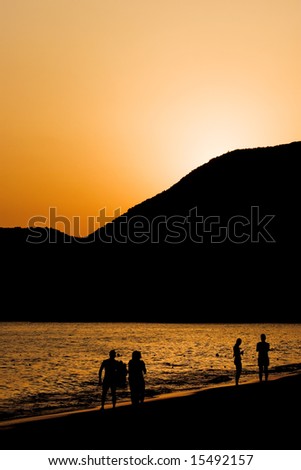 sunset with people silhouettes on a beach