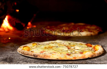 delicious pizza baking in wood fired oven