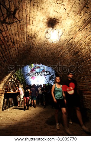 NOVI SAD, SERBIA - JULY 7: People in a tunnel leading to the Dance Arena at EXIT 2011 Music Festival, during DEADMAUS5 performance, on July 7, 2011 in the Petrovaradin Fortress in Novi Sad.