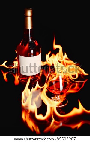 wine brandy bottle and a glass with fire