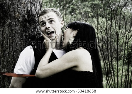 Woman biting man in the forest