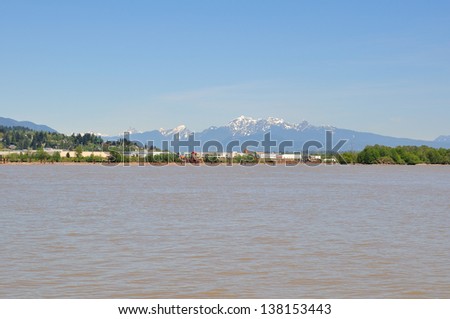 fraser river with scenic river bank and snow mountains
