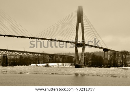 Skytrain Bridge across Fraser River floating ice in the winter (Black and White)