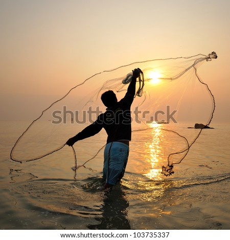 stock photo : throwing fishing net during sunrise, Thailand