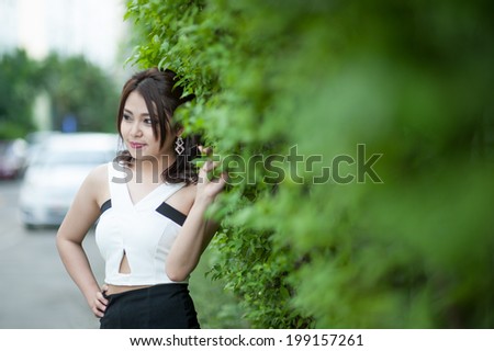 Beautiful Teenage Model girl Dressed in Casual Short Dress on green leaf