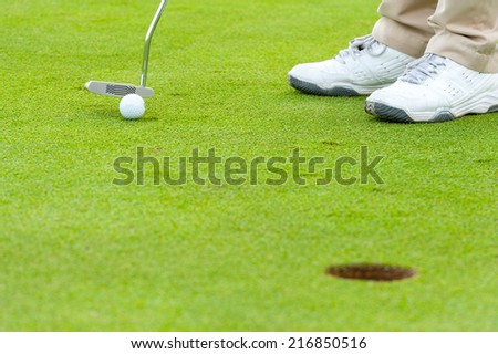 Golf man putting on green
