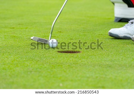 Golf man putting on green