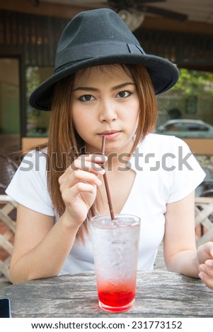 Portrait of young woman drinking strawberry italian soda