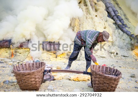 BANYUWANGI, EAST JAVA JULY 20 : Sulphur miner points to hardened sulphur from the ground to be collected and sold on July 20, 2013, Ijen volcano, East Java, Indonesia.