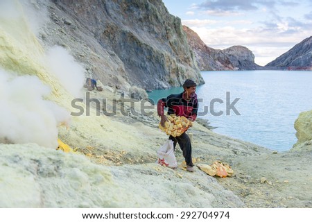BANYUWANGI, EAST JAVA JULY 20 : Sulphur miner points to hardened sulphur from the ground to be collected and sold on July 20, 2013, Ijen volcano, East Java, Indonesia.