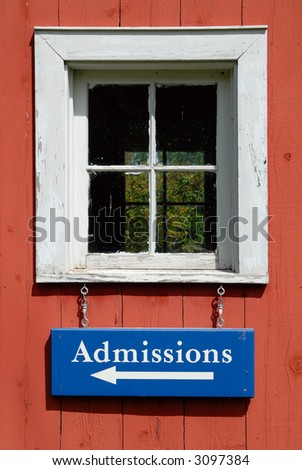 Admission sign hanging from a window of an old building